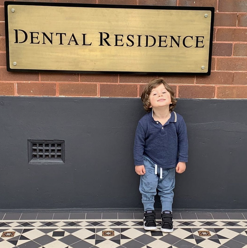 Young boy in front of the dental residence - marrickville dentist sign.